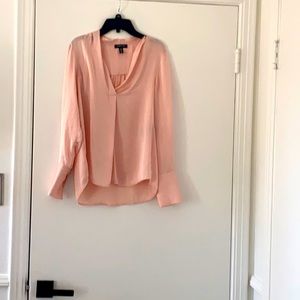 Billowy pink blouse with v-neck neckline.